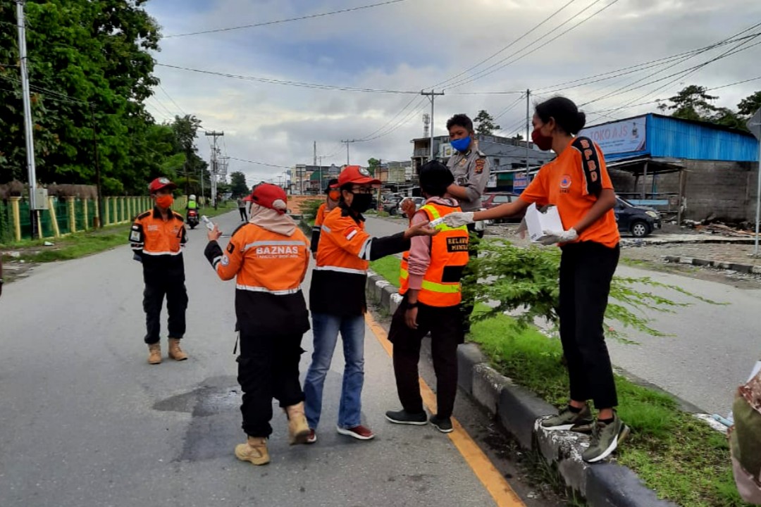 Petugas BPBD Mimika membagikan Hand Sanitizer kepada petugas yang menjaga jalan. (Foto: Ist/SP)