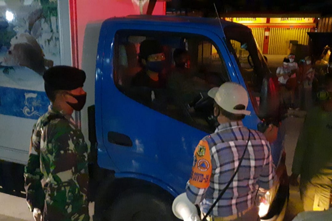 HIMBAUAN | Petugas gabungan memberikan imbaun kepada salah satu supir yang masih beraktivitas di atas jam 7 malam. (Foto: Aditra/SP)
