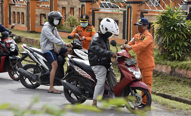 BAGI BENDERA | Personel Kantor Pencarian dan Pertolongan Timika ketika membagikan bendera merah putih kepada pengendara sepeda motor. (Foto: Humas SAR Timika)