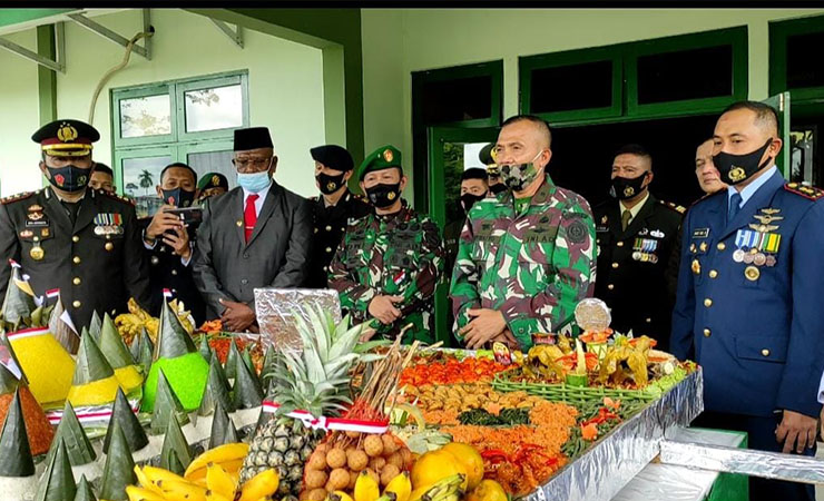 TUMPENG - Kapolres Mimika AKBP I Gusti Gde Era Adhinata saat menyerahkan tumpeng raksasa di HUT TNI ke 75. (Foto : Muji/SP)