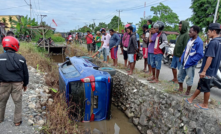 MASUK PARIT | Sebuah mobil masuk parit di kawasan Irigasi, Jalan Hasanuddin, Mimika, Papua. (Foto: Ist/SP)
