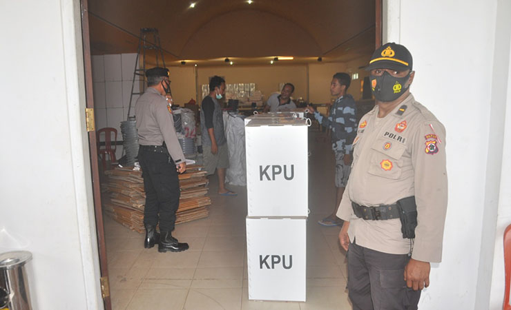 BERJAGA - Petugas kepolisian tengah berjaga saat pendistribusian logistik Pilkada di Merauke. (Foto: M. Dul)