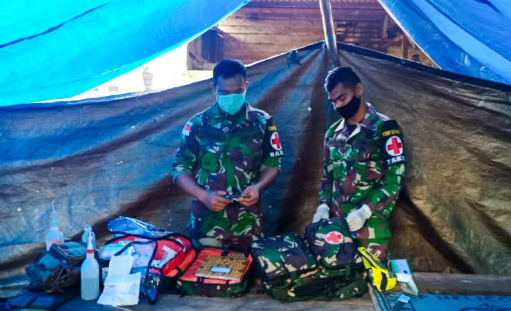 PERSIAPKAN ALAT | Dua Prajurit TNI dari Satgas Yonif 611/ Awang Long saat mempersiapkan peralatan untuk membantu persalinan warga. (Foto: Satgas Yonif 611/ Awang Long)