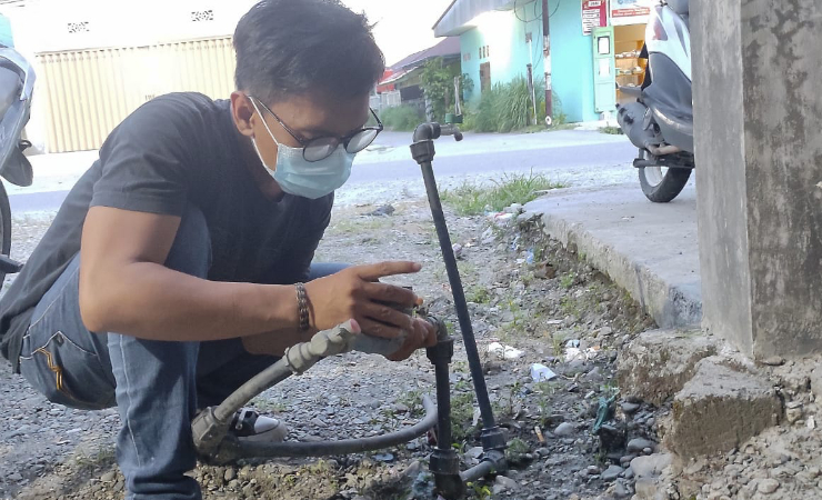 CEK | Salah satu warga di Mimika tengah mengecek instalasi air bersih yang sudah masuk ke rumah-rumah warga. (Foto: Mujiono/Seputarpapua)