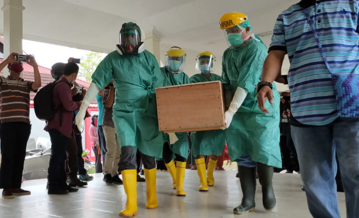 ANGKAT | Peti berisi jenazah Yonatan Renden diangkat petugas kamar jenazah RSUD Mimika untuk dimandikan dan dilakukan pemulasaraan, Sabtu (10/4/2021). (Foto: Saldi/Seputarpapua)