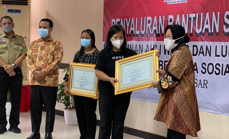 PIAGAM | Menteri Sosial Tri Rismaharini menyerahkan piagam penghargaan kepada dua guru korban penembakan di Puncak, Papua. (Foto: Atjong/Torajadaily.com)