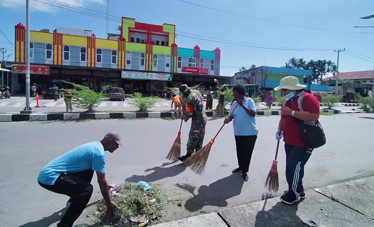BERSIH | Warga Kelurahan Inauga dan Kamoro Jaya kerja bakti di Jalan Hasanudin. (Foto: Anya Fatma/Seputarpapua)