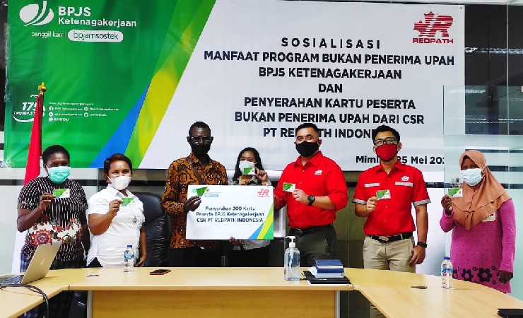 PENYERAHAN | Manager HR-IR PT Redpath Indonesia menyerahkan secara simbolik kartu BPJS Ketenagakerjaan kepada Kepala Kampung Pomako. (Foto: Muji/Seputarpapua)