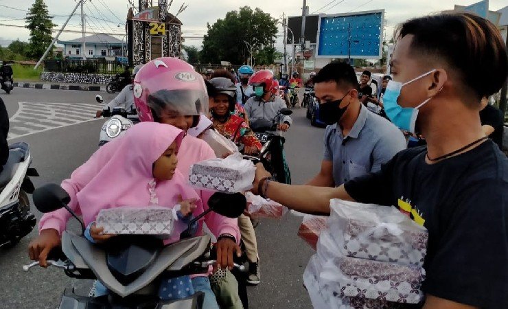 BERBAGI | Anggota Komunitas Roda Empat Timika membagikan hidangan buka puasa ke pengguna jalan di Timika, Papua. (Foto: Ist/Seputarpapua)