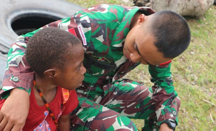DEKAT | Seorang prajurit TNI AD berbincang dengan seorang anak kecil di Mimika. (Foto: Yonri/Seputarpapua)