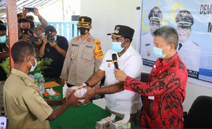 Bupati Keerom, Pieter Gusbager menyerahkan langsung dana desa tahap I kepada salah satu kepala kampung. (Foto: Amin M/ Seputarpapua)