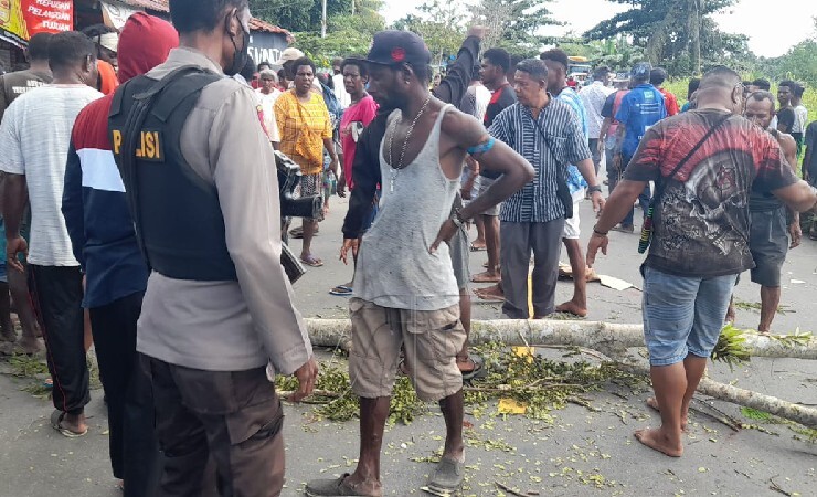 PALANG JALAN | Massa lakukan pemalangan di Jalan Poros Poumako akibat insiden penikaman, Minggu (1/8/2021). (Foto: Polsek Miktim)