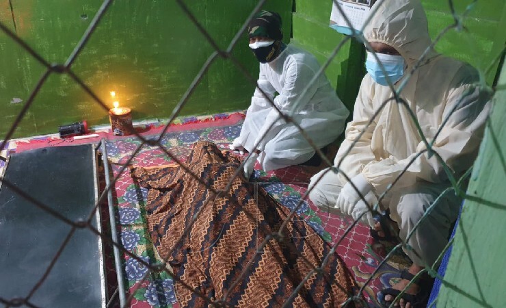 Anggota Polres Mimika, Brigadir Anton Rawar dan seorang warga lainnya mengevakuasi jenazah korban di Kampung Wangirja, Mimika, Jumat (30/7/2021). (Foto: Ist/Seputarpapua)