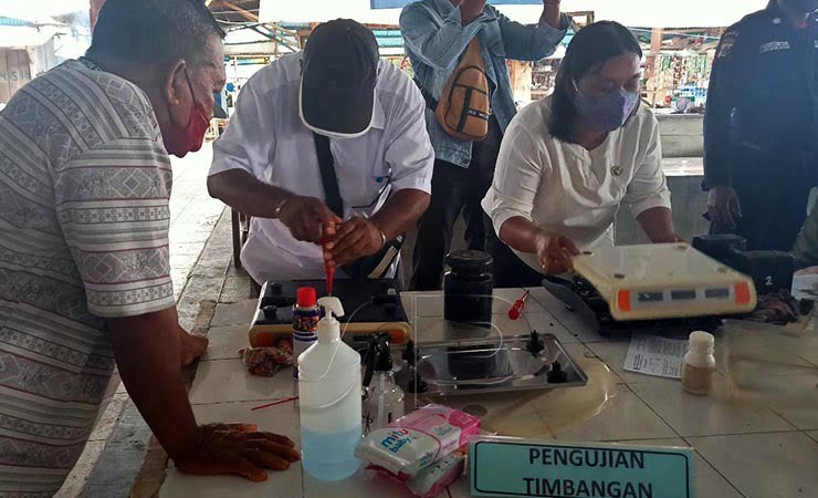 PENGUJIAN | Pegawai Disperindag saat melakukan proses tera/tera ulang yang disaksikan oleh pedagang pemilik timbangan. (Foto: Kristin Rejang/Seputarpapua)