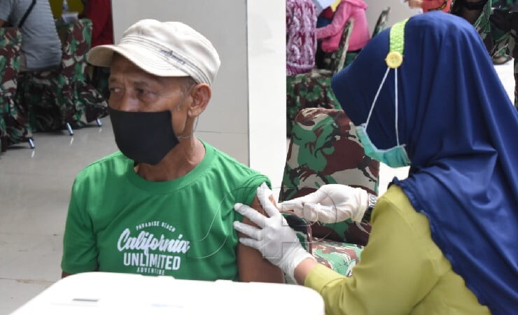 SUNTIK | Seorang warga di Terminal Pasar Wosi menerima suntikan vaksin dari tenaga vaksinator dalam program serbuan vaksinasi oleh TNI. (Foto: Pendam XVIII/Kasuari)