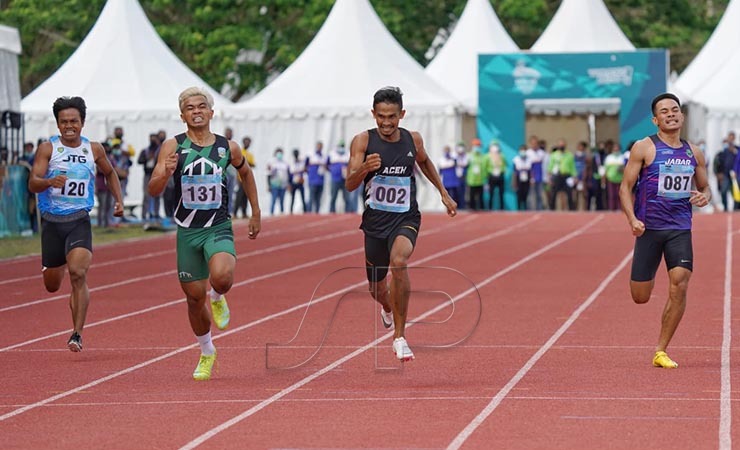 002 Fuad Ramadhan (hitam) atlet asal Aceh berhasil finis terdepan dinomor lari 400 meter putra pada Pekan Olahraga Nasional (PON) XX Papua di arena atletik Mimika Sport Complex, Selasa (12/10/2021). (Foto: Humas PPM/Fernando Rahawarin.)