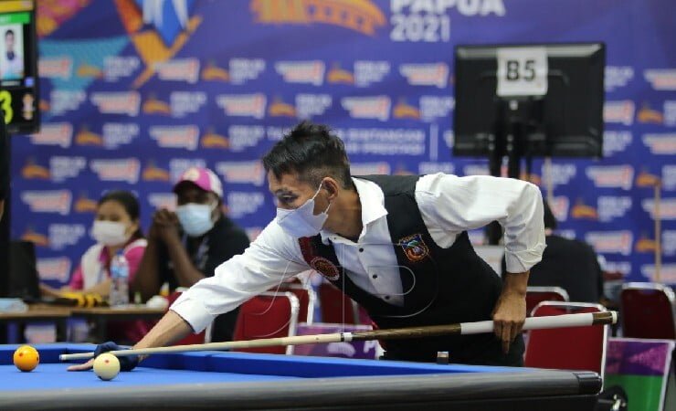 Pebiliar Papua James Lengkang mengalahkan pebiliar Sumatera Utara Hotmaruli Simarmata di partai final Cushion Single dengan skor telak 100-37, berlangsung di Venue Billiar Mimika, Selasa (5/10/2021). James adalah peraih empat medali emas atau penyapu bersih divisi carom PON Jabar 2016. (Foto: Humas PPM PB PON XX / SEVIANTO PAKIDING)