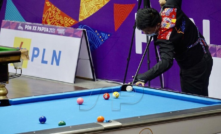 Pebiliar DKI Jakarta Ponco K. melakukan pukulan Jump Shot dalam babak final nomor 10 Ball Double Cabor Biliar PON XX Papua, Senin (11/10/2021). Bersama pasangannya Edward berhasil merebut medali emas usai mengalahkan pasangan dari Sumatera Utara, M Fadly dan Jefri Z. (FOTO: HUMAS PPM/SPEDY PAERENG)