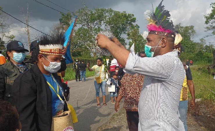 Ketua Binfora Timika, Richard Wakum saat mengalungkan pinang sirih kepada ketua Kontingen Kabupaten Supiori, Yulia Kafiar. (Foto: Kristin Rejang/Seputarpapua)