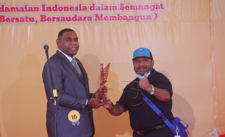 Ketua Kontingen Kabupaten Jayapura Jhon Wicklif Tegai befoto dengan peserta Solo Putra peraih emas (Foto: Sevianto Pakiding/Seputarpapua)