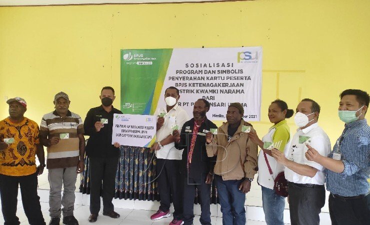 KARTU | Penyerahan kartu BPJS Ketenagakerjaan secara simbolik dari Staf HR-IR PT Pangansari Utama kepada Kepala Distrik Kwamki Narama dan sejumlah warga. (Foto: Mujiono/Seputarpapua)