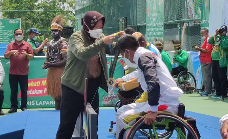 PENYERAHAN MEDALI | Menteri Sosial Tri Rismaharini menyerahkan medali emas kepada Agus Fitriadi. (Foto: Wandi/ Seputarpapua)