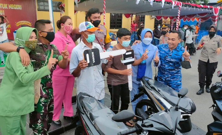 HADIAH | Dua warga yang mengikuti vaksinasi di Gebyar Vaksin alumni Akabri 2001, Selasa (28/12/2021), mendapatkan doorprize dengan hadiah utama 2 unit sepeda motor. (Foto: Saldi/Seputarpapua)