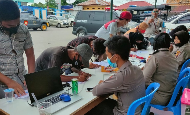 MENDAFTAR | Warga Mimika mendaftarkan diri untuk mengikuti program vaksinasi Covid-19 di gerai vaksinasi Kantor Pelayanan Polres Mimika, Papua. (Foto: Saldi/Seputarpapua)