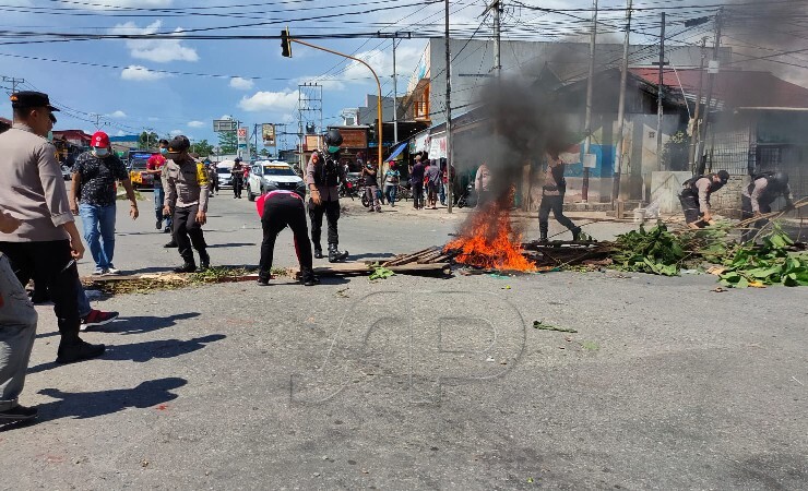 Polisi bongkar palang jalan di perempatan SP1-SP4 Timika, Papua pada Rabu (26/1/2022) siang. Sebelumnya, warga digegerkan oleh penemuan mayat di KM 7 dan akhirnya lakukan palang jalan