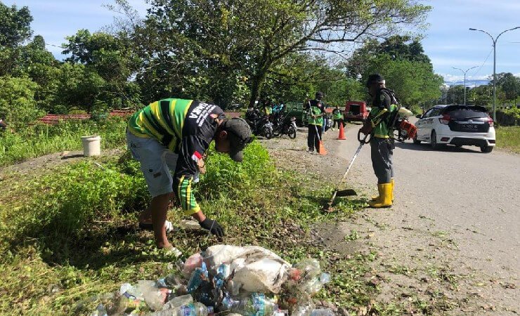 KAMGAS | Anggota Kamgas saat membersihkan area badan jalan di area TPU SP 3. (Foto: Anya Fatma/Seputarpapua)