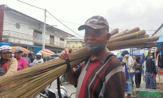 La Hamidu memikul sapu lidi yang dijualnya di depan Masjid Babussalam, Timika, Kamis (7/4/2022). (Foto: Kristin Rejang/Seputarpapua)