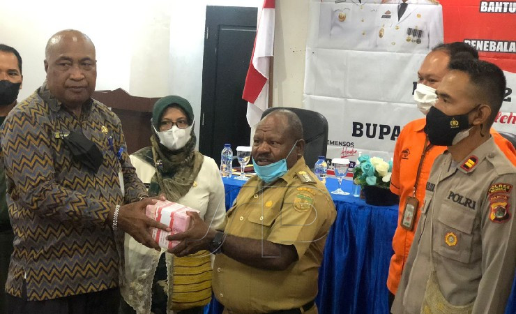 Asisten I Setda Mimika menyerahkan uang tunai kepada kepala distrik Jila. (Foto: Anya Fatma/Seputarpapua)