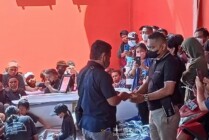 SERAHKAN | Ketua IKT Puncak, Mulianto menyerahkan bantuan kepada perwakilan keluarga Nober Palintin, di Cargo Bandara Mozes Kilangin Timika, Jumat (13/5/2022). (Foto: Ist)