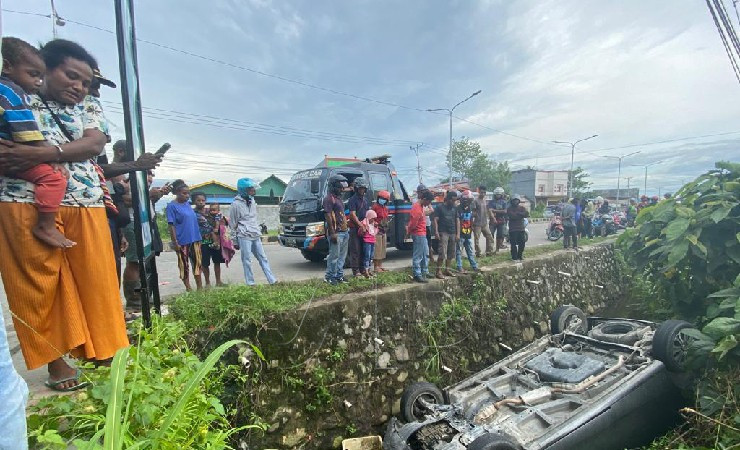 Mobil honda freed terbalik di dalam parit setinggi kurang lebih dua meter dan hebohkan warga di Jalan Hasannudin, Timika, Papua pada Kamis (19/5/2022) pagi. (Foto: Yonri/Seputarpapua)