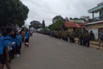 Masyarakat berdiri di pinggir jalan menanti rombongan Komisi II DPR RI