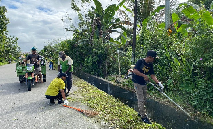 Kepala Kelurahan Kamoro Jaya, Musdahlifa (kanan) bersama stafnya membersihkan ruas Jalan Budi Utomo SP 1, Timika, Papua Tengah pada Jumat (21/7/2022). (Foto: Yonri/Seputarpapua)
