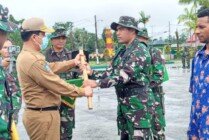 Penyerahan alat kerja dari perwakilan Pemkab Mimika kepada seorang personel TNI dalam upacara pembukaan TMMD Reguler ke 114 Kodim 1710/Mimika. (Foto: Ist)