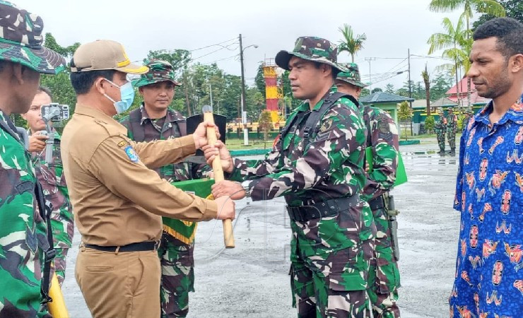 Penyerahan alat kerja dari perwakilan Pemkab Mimika kepada seorang personel TNI dalam upacara pembukaan TMMD Reguler ke 114 Kodim 1710/Mimika. (Foto: Ist)