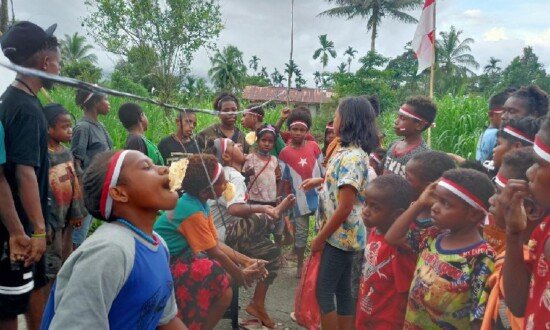 Anak-anak Kampung Mulia Kencana saat mengikuti perlombaan makan kerupuk. (Foto: Kristin Rejang/Seputarpapua)