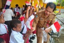 Kepala Badan Kesbangpol, Yan Selamat Purba saat membagikan bendera Merah Putih kepada siswa SD. (Foto: Ist for Seputarpapua)