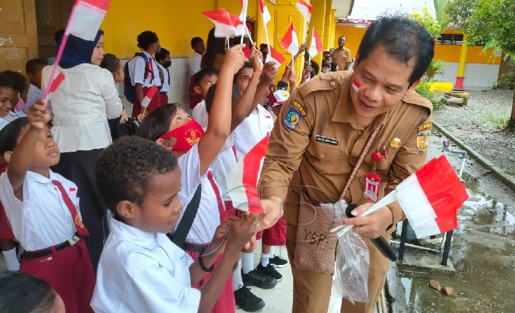 Kepala Badan Kesbangpol, Yan Selamat Purba saat membagikan bendera Merah Putih kepada siswa SD. (Foto: Ist for Seputarpapua)