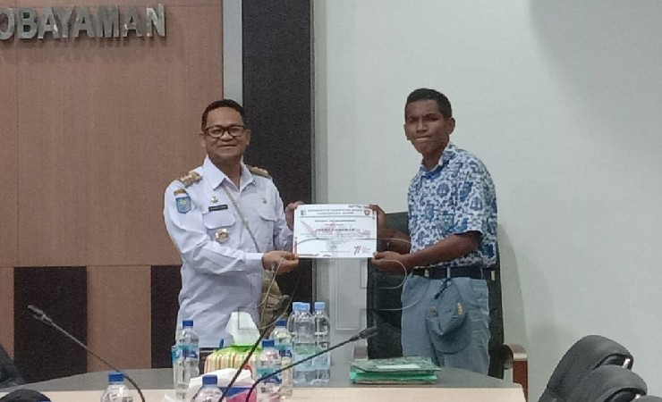 Pj Bupati Mappi Michael R. Gomar memberikan sertifikat piagam penghargaan kepada salah satu anggota Paskibra. (Foto: Ist)