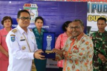 Penjabat Bupati Mappi Michael R. Gomar memberikan cinderamata kepada Ketua Komisi Informasi Provinsi Papua Wilhemus Pigai, Rabu (28/9/2022).