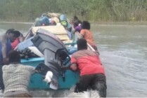 Warga di pesisir Mimika mendorong perahu yang terperangkap di sungai yang mengalami pendangkalan. (Foto: Ist)