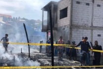 Petugas Kepolisian memasang garis polisi pada lokasi kebakaran di kompleks kampung baru Dok IX, Distrik Jayapura Utara, Kota Jayapura, Papua. (Foto: Ist)
