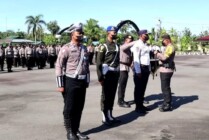 Kapolres Mimika AKBP I Gede Putra menyematkan pita Operasi Zebra Cartenz 2022 kepada perwakilan Pemerintah Kabupaten Mimika dalam apel pasukan di Mapolres Mimika, Senin (3/10/2022). (Foto: Cahyo, Humas Polres Mimika)