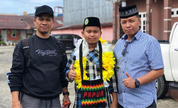 Syahrul Maulana Ismail (tengah) berfoto dengan Ketua LPTQ Mimika Dwi Cholifah (kanan) dan ayahnya Ustadz Ismail (kiri). (Foto: Anya Fatma/Seputarpapua)