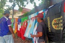 Abai (topi merah) saat melayani pembeli bendera piala dunia. (Foto: Kristin Rejang/Seputarpapua)