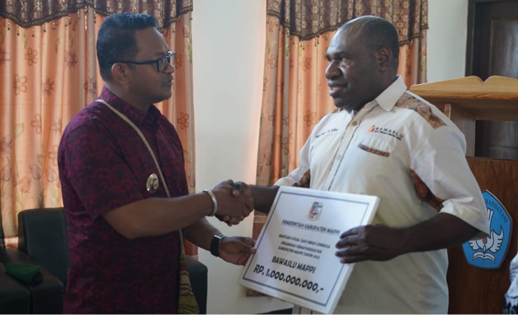 Penjabat Bupati Mappi Michael Gomar menyerahkan bantuan dana hibah untuk Bawaslu, Jumat (25/11/2022). (Foto: Ist)