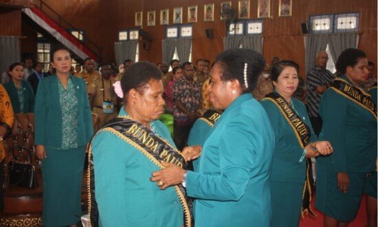 Ketua Bunda PAUD Asmat Orpa Susana Kambuaya Kambu memasangkan slempang pada pengukuhan Bunda PAUD Tingkat Distrik, Kamis (24/11/2022). (Foto: Elgo)